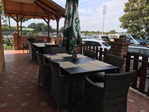 a table with an umbrella on a patio at Sport Hotel in Tatabánya