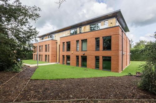 a brick building with a green lawn in front of it at Greenlands Hotel in Henley on Thames
