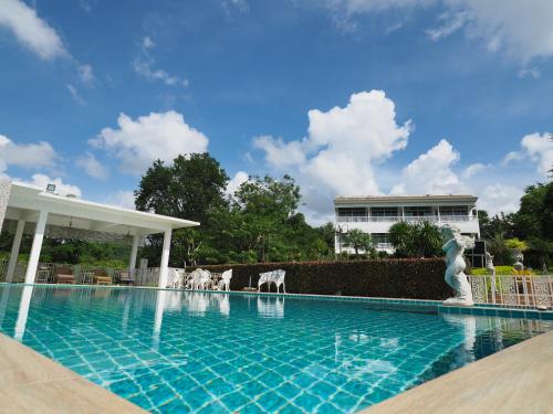 ein Schwimmbad mit Statuen in der Mitte eines Gebäudes in der Unterkunft Baan Ing Khao in Pak Chong