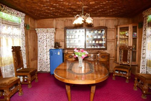 a room with a table with a vase of flowers on it at White House Group Of Houseboats in Srinagar