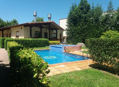 a swimming pool in the yard of a house at Apartamentos El Cazador in San Vicente de Toranzo