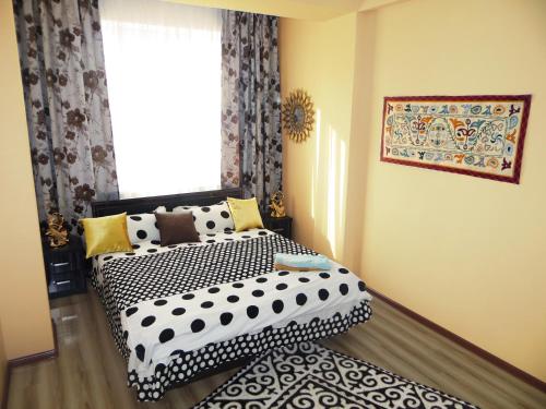 a bedroom with a black and white bed and a window at Apartment Kievskaya 114/2 in Bishkek