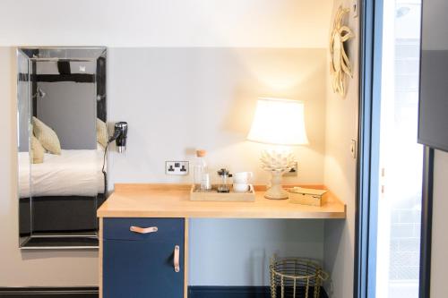 a room with a desk with a bed and a mirror at The White Horse in Hertingfordbury