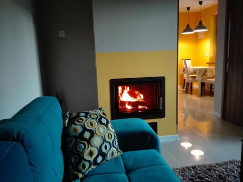 a blue couch in a living room with a fireplace at GOLD apartamenty & spa in Szczawnica
