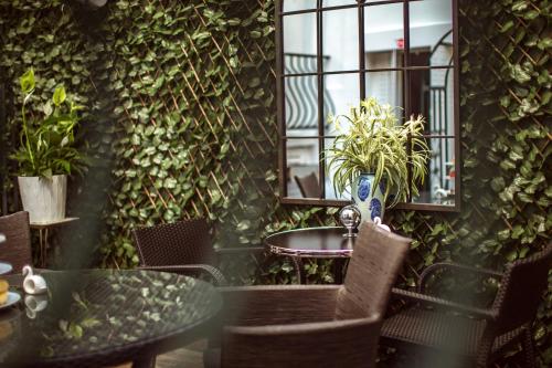 une table et des chaises dans une pièce avec des plantes dans l'établissement La Maison Gobert Paris Hotel Particulier, à Paris