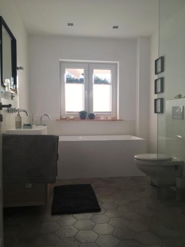 baño con bañera y aseo y 2 ventanas en Schwedenvilla Estelle, en Dörphof