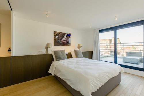 a bedroom with a bed and a large window at The Livorno in Brussels