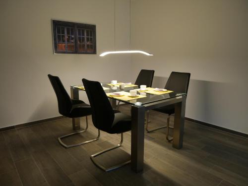 mesa de comedor con sillas negras y luz en Apartment Haltern, en Haltern