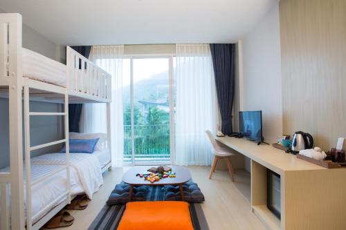 a bedroom with a bed and a desk and a window at LaRio Hotel Krabi-SHA Extra Plus in Ao Nang Beach