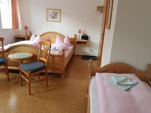 1 Schlafzimmer mit 2 Betten, einem Tisch und Stühlen in der Unterkunft Gasthaus und Hotel Peterhänsel in Spechtsbrunn