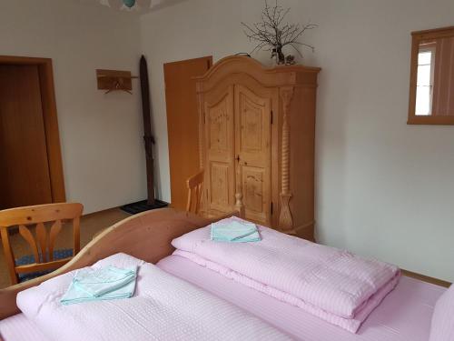 a bedroom with two beds and a wooden headboard at Gasthaus und Hotel Peterhänsel in Spechtsbrunn