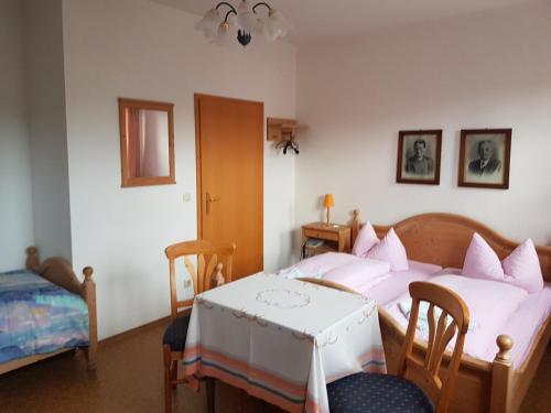 1 dormitorio con 2 camas y mesa. en Gasthaus und Hotel Peterhänsel, en Spechtsbrunn