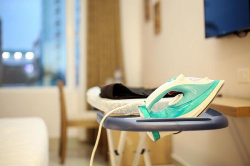 a hospital room with a table with a blue and white iron at Sidra Pristine Hotel and Portico Halls in Cochin
