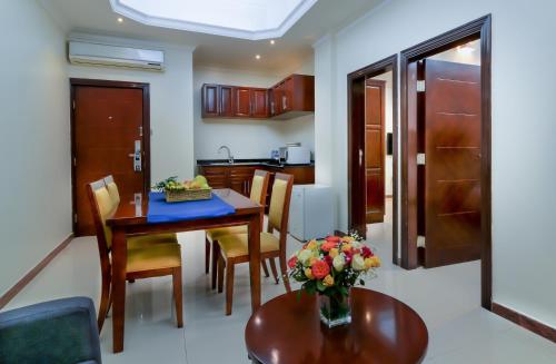 cocina y comedor con mesa y sillas en Tanzanite Executive Suites en Dar es Salaam