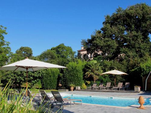- une piscine avec des chaises et des parasols à côté dans l'établissement Domaine du Pegulier, à Montaut-Ariège
