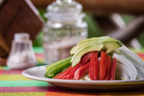 a sandwich on a plate with vegetables on a table at Las Guacamayas Lodge, Selva Lacandona, Chiapas México in Tlatizapán