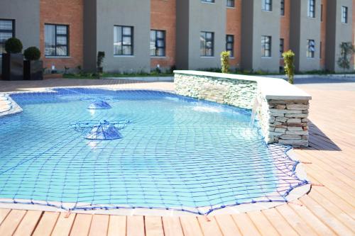a swimming pool in a courtyard with a building at Regal Inn Hotel Midrand in Midrand