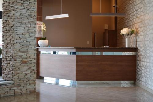 a lobby with a counter and a brick wall at Regal Inn Hotel Midrand in Midrand