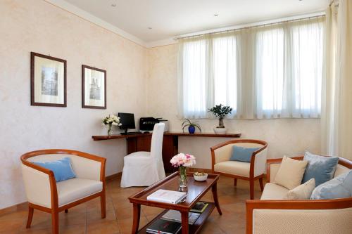 a living room with a couch and chairs and a table at Dea Suite Roma in Rome