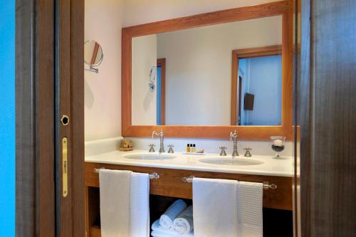 a bathroom with two sinks and a large mirror at Dea Suite Roma in Rome
