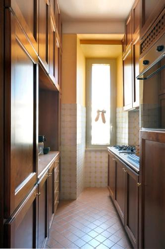 a kitchen with wooden cabinets and a window in it at Dea Suite Roma in Rome