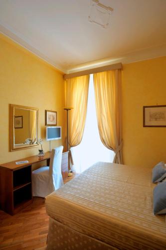 a bedroom with a bed and a desk and a mirror at Dea Suite Roma in Rome