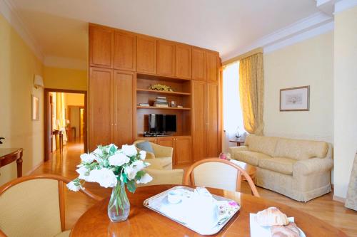 a living room with a vase of flowers on a table at Dea Suite Roma in Rome