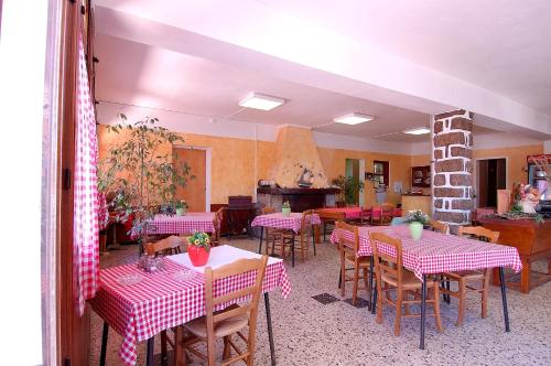 um restaurante com mesas e cadeiras e um piano em Residence I Delfini em Tiuccia