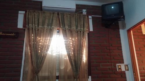 a window with a curtain and a television at Apart Termal San Ramon in Termas de Río Hondo