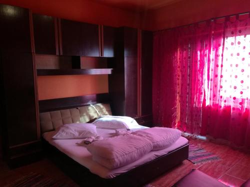 a bedroom with a bed with a red curtain at Odvojak Apartments in Crikvenica