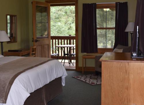 a bedroom with a bed and a desk and a balcony at Champions Black Bear Lodge in Delhi