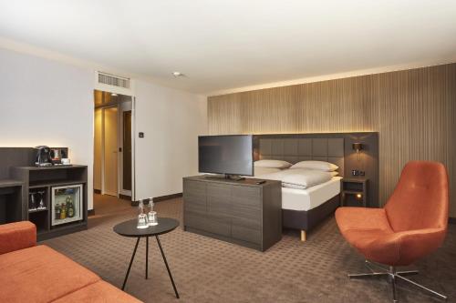 a hotel room with a bed and a television at H4 Hotel Residenzschloss Bayreuth in Bayreuth