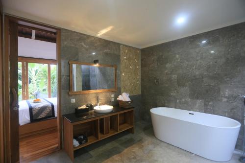 uma casa de banho com uma banheira grande e um lavatório em Ume Sri Villas Ubud em Ubud