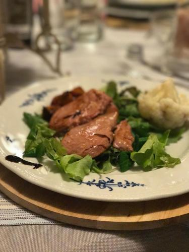 a plate of food with meat and greens on a table at Hotel Florence in Manerba del Garda