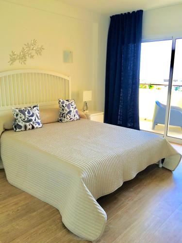 a bedroom with a large bed with pillows on it at Club Playa Flores in Torremolinos