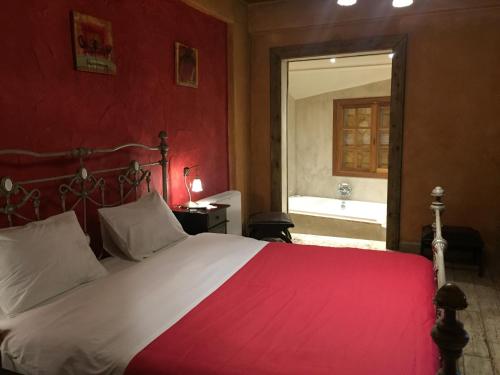 una camera con un grande letto con una parete rossa di Enthymio Suites a Synikia Mesi Trikalon