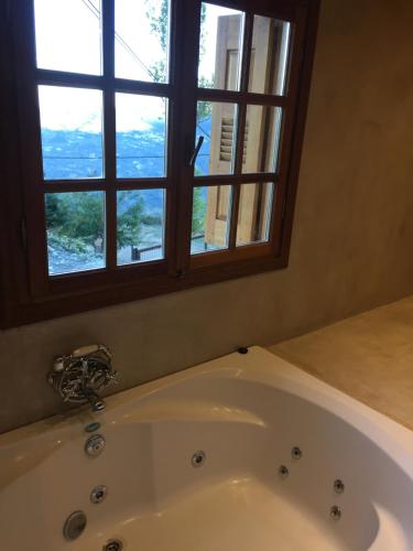 a bath tub in a bathroom with a window at Enthymio Suites in Synikia Mesi Trikalon