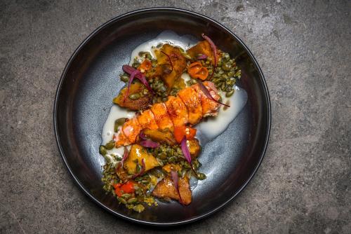a plate of food with fish and vegetables on a table at MADE Hotel in New York
