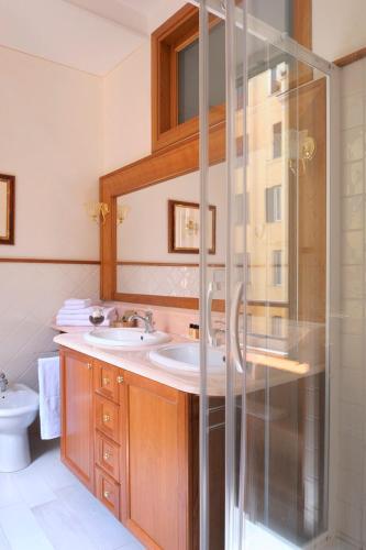 a bathroom with two sinks and a shower at Dea Suite Roma in Rome