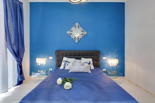 a blue bedroom with a large bed with two lamps at Louise at Colosseum in Rome