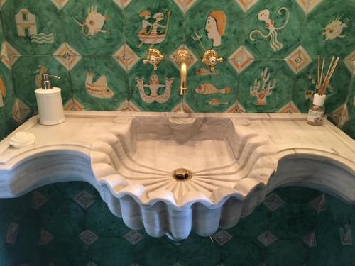 a sink in a bathroom with a green wall at Palazzo Suriano Heritage Hotel in Vietri sul Mare