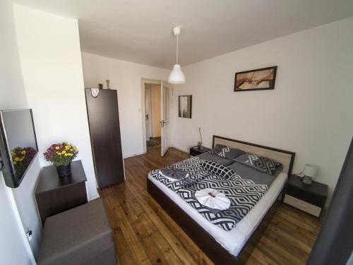 a bedroom with a black and white bed and wooden floors at Graf Ignatiev - 3BR APART in Sofia