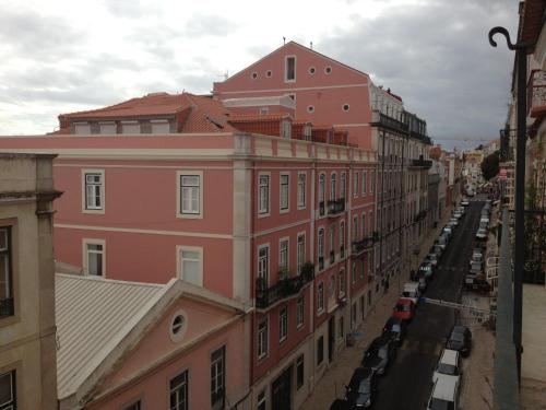 a row of buildings on a street with parked cars at Verde Esperança in Lisbon