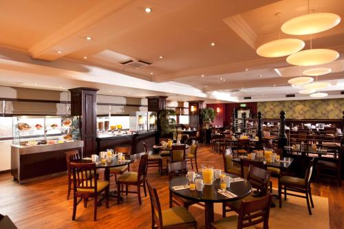 a restaurant with tables and chairs and a bar at Leonardo Inn Glasgow West End in Glasgow