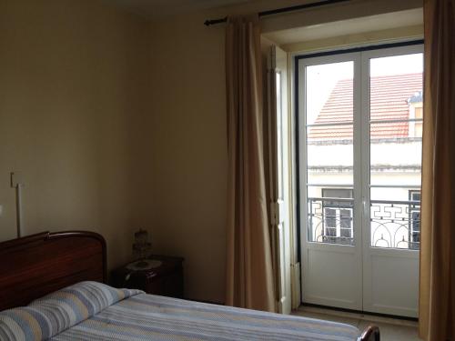 1 dormitorio con 1 cama y puerta corredera de cristal en Verde Esperança, en Lisboa