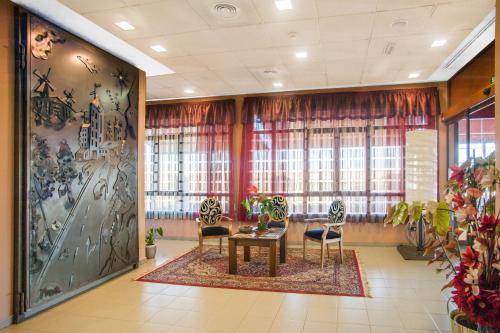a lobby with a table and chairs and windows at Hotel Moya in Honrubia