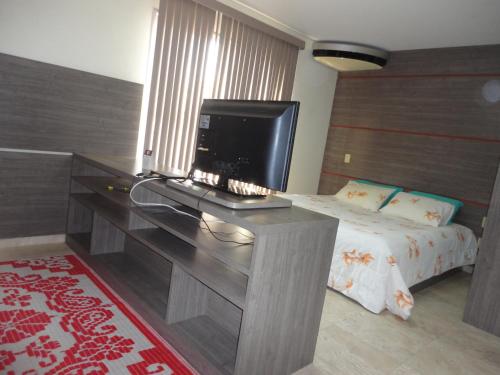a bedroom with a desk with a television on it at Flat Privado Manaus in Manaus