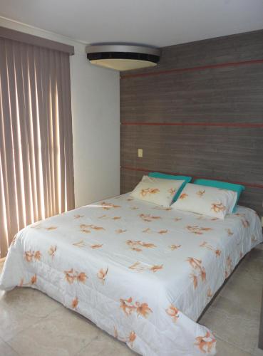Un dormitorio con una gran cama blanca con flores. en Flat Privado Manaus en Manaus