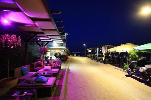 a group of people sitting on tables at a restaurant at night at Apartment Abba in Kali