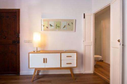 a bathroom with a table with a lamp on it at Canavall in Palma de Mallorca